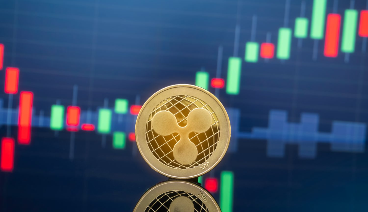Ripple (XRP) and cryptocurrency investing concept - Physical metal Ripple coins with global trading exchange market price chart in the background.
