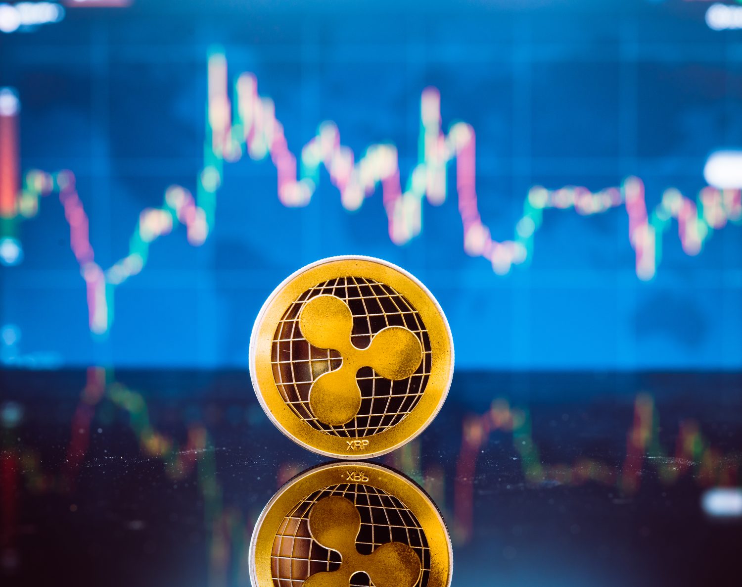 Bitcoin and XRP, gold virtual bit coin and xrp money currency on digital candle stick graph chart background