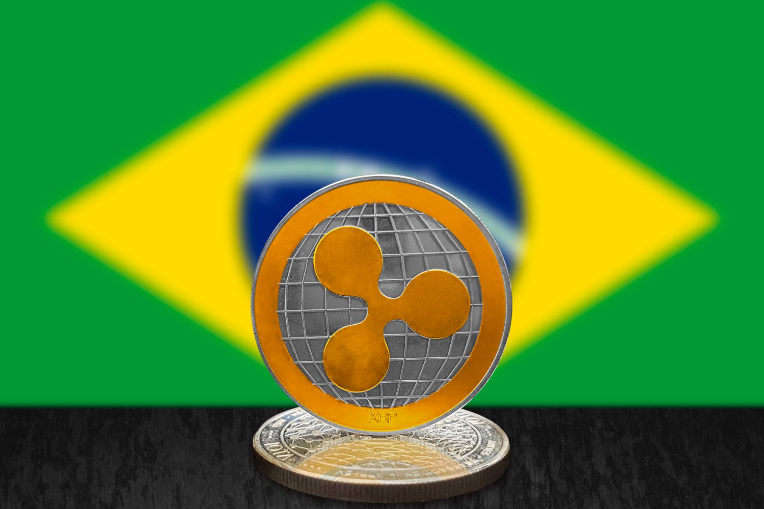 Ripple XRP on cryptocurrency coin with Brazilian flag in background. The cryptocurrency coin is golden and in focus. This is a Brazil Ripple concept.