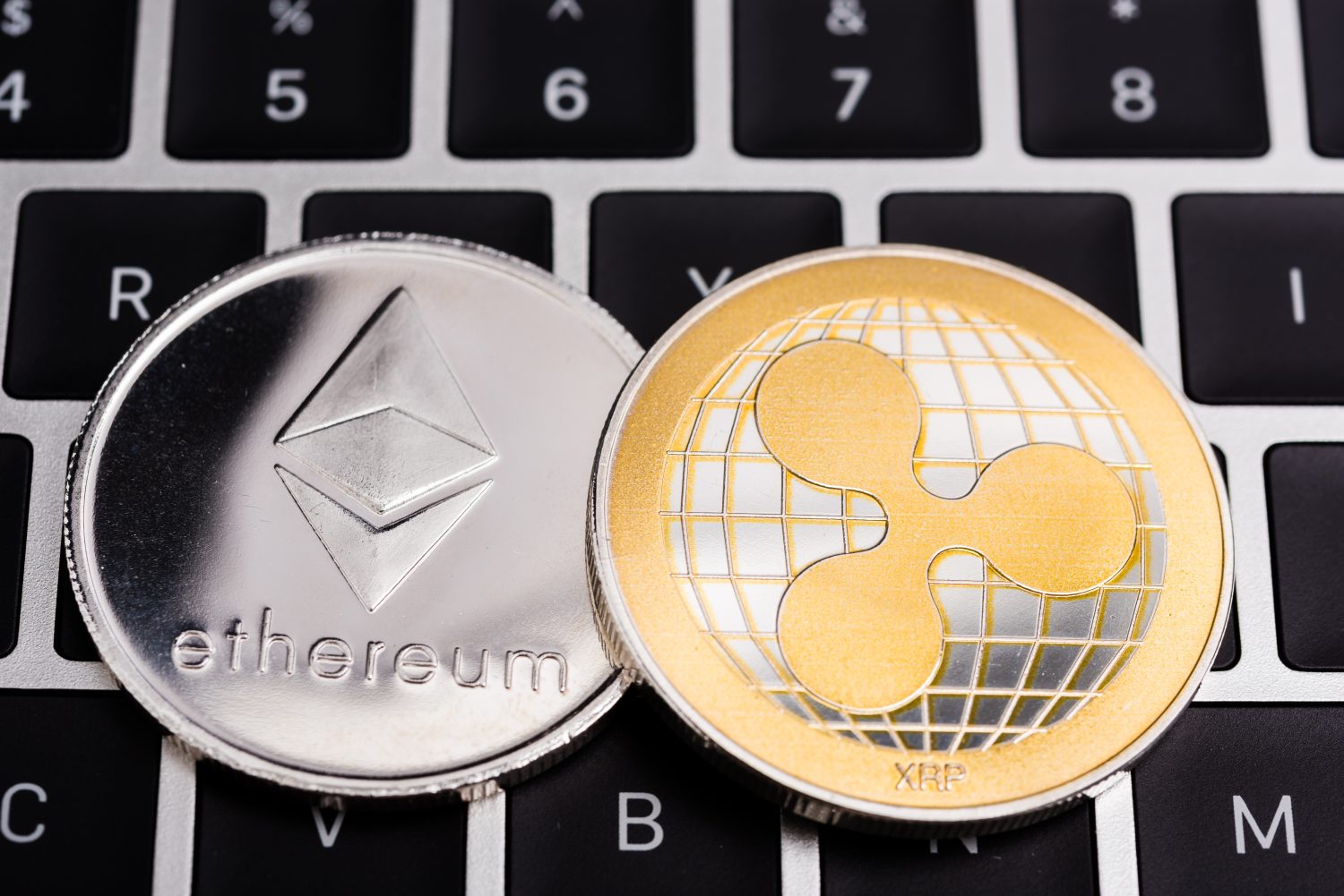 Virtual Ethereum and ripple XRP coins currency finance money on computer laptop keyboard