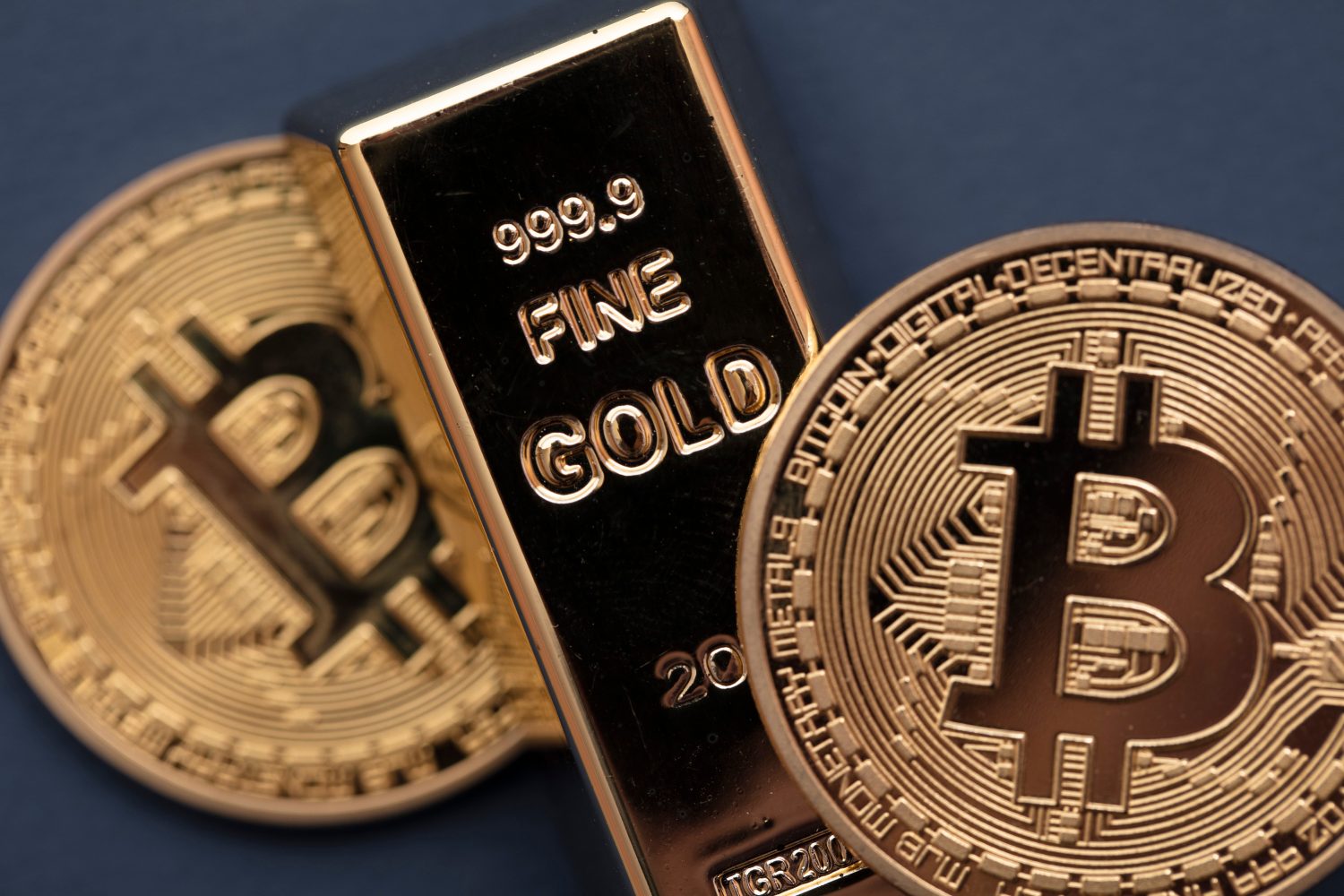 Bitcoin cryptocurrency coin with a gold bullion bar. Investment concept