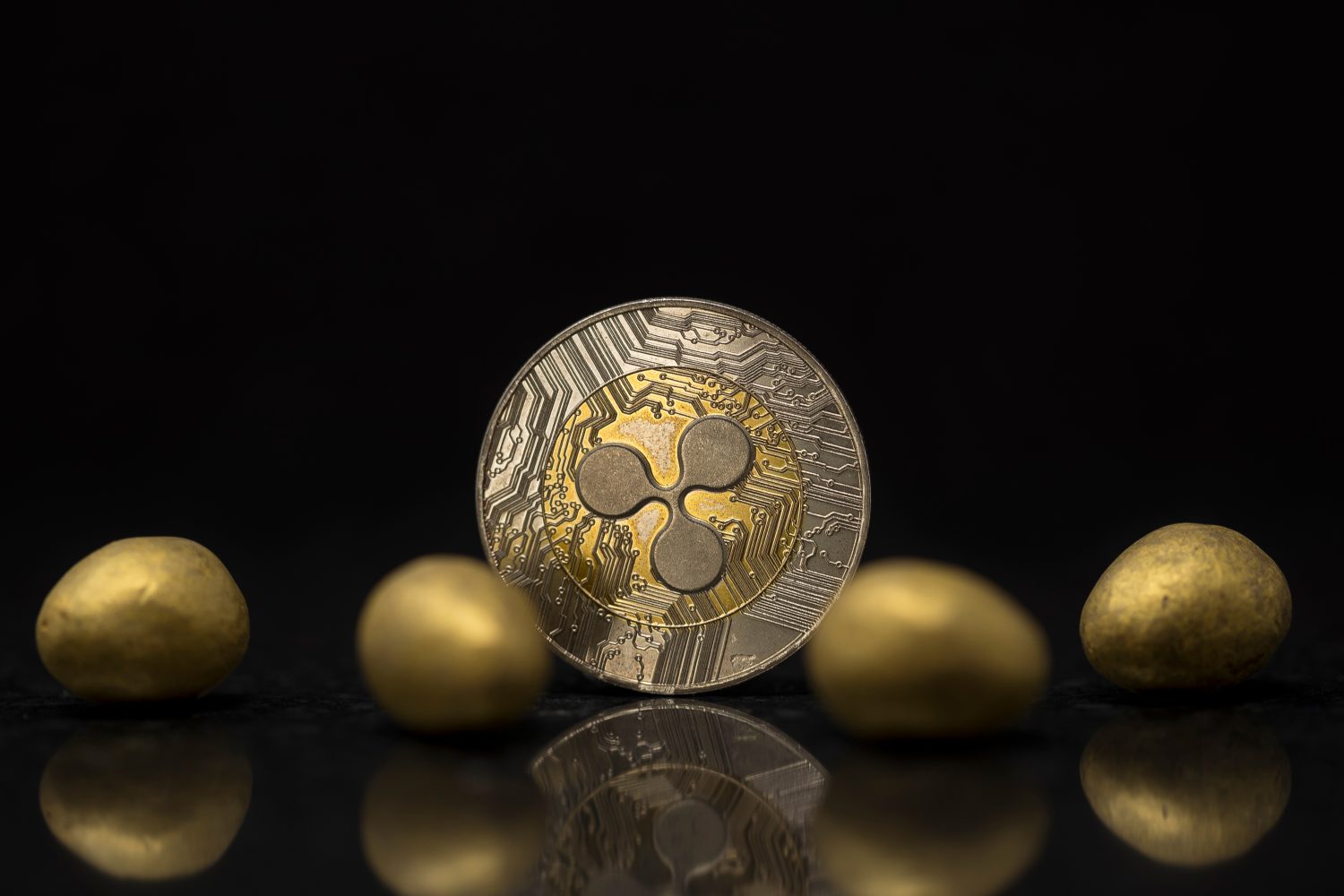 Ripple cryptocurrency physical coin surrounded with little golden Easter eggs
